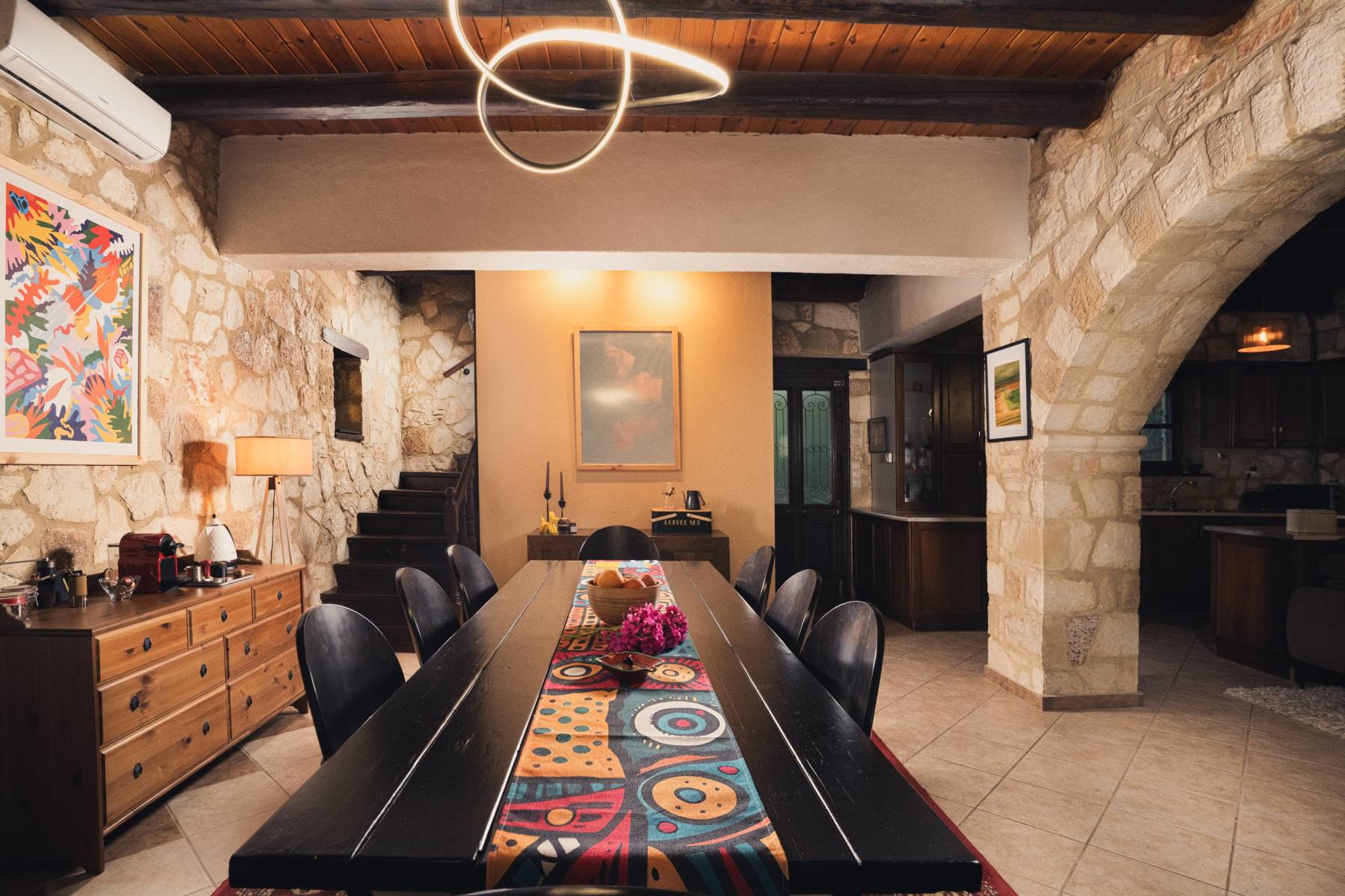 Dining table with a patterned runner near the staircase