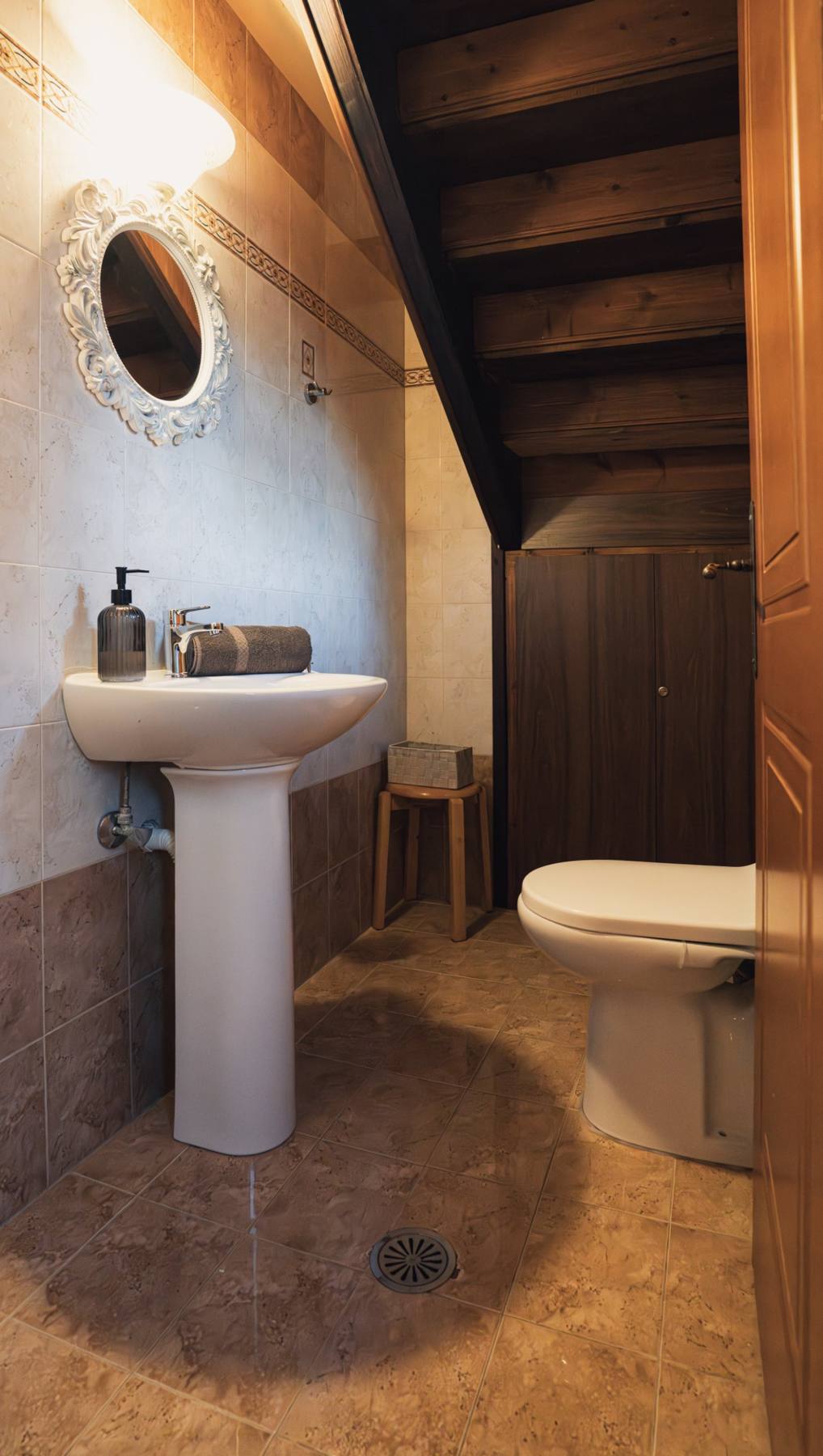 Bathroom under the stairs with a pedestal sink