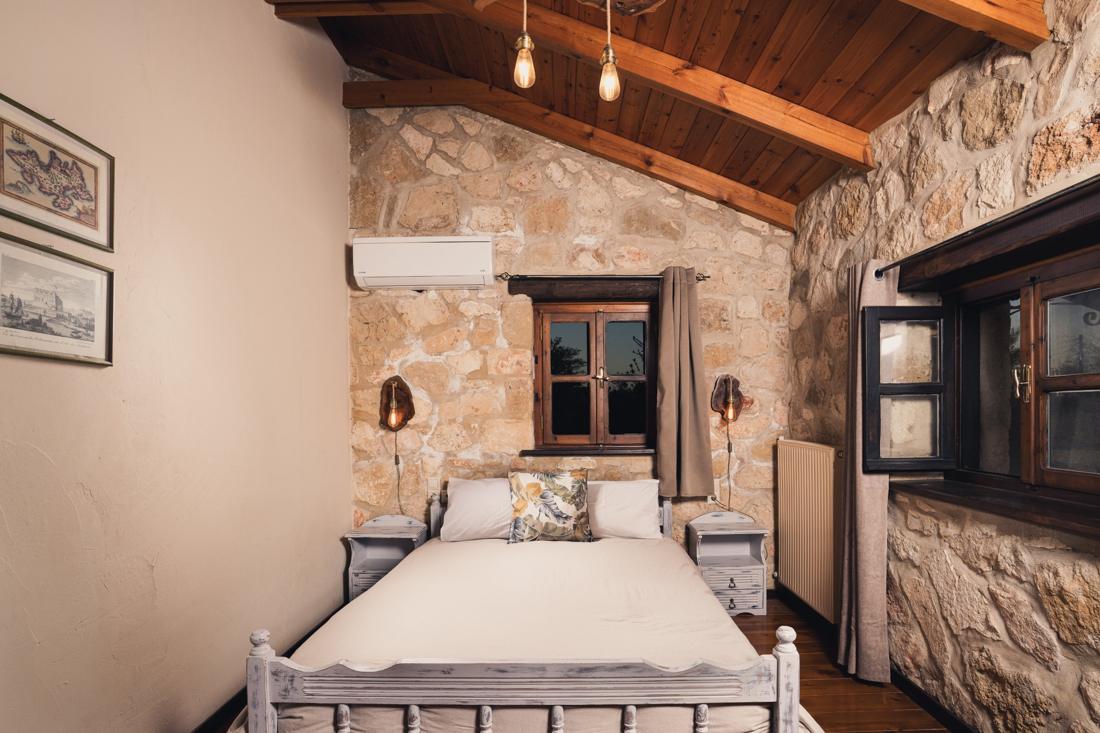 Bedroom with an iron bed under a wood-beamed ceiling