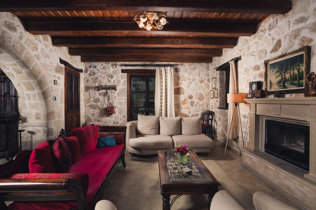 Living room with a red sofa and stone walls