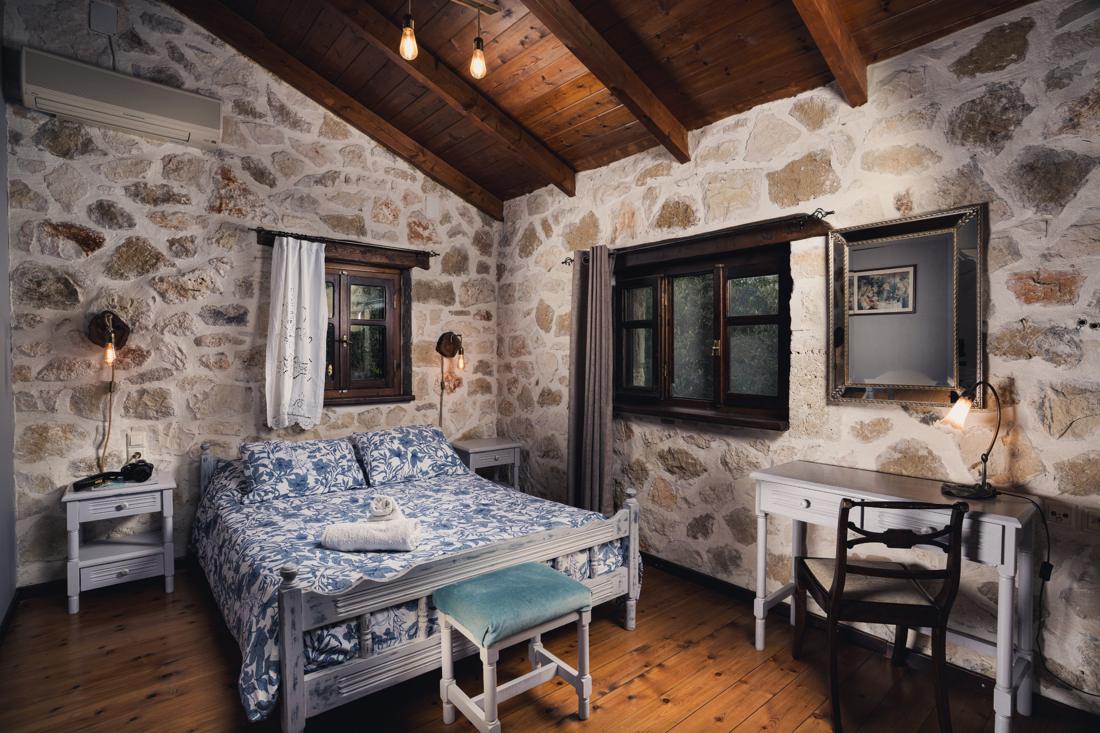 Bedroom with blue floral bedding and stone walls