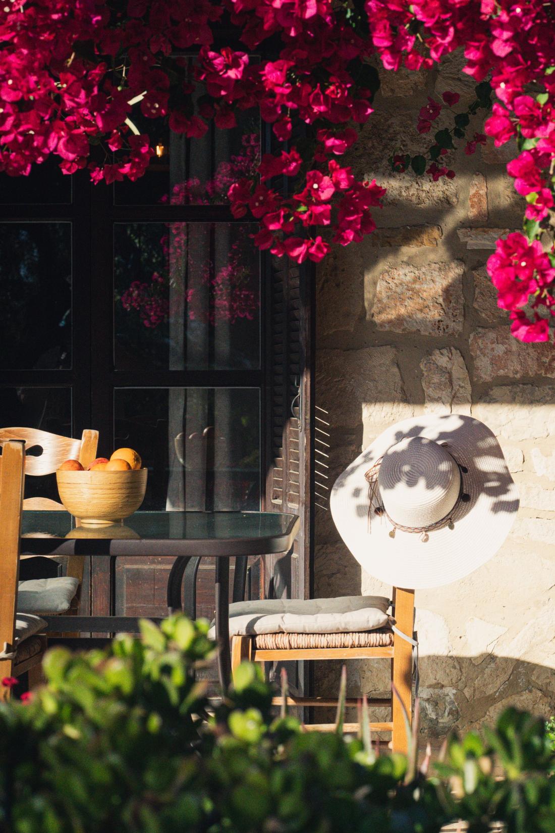 Garden table set for breakfast under bougainvillea