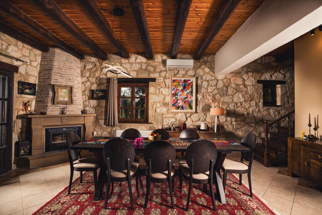 Dining room with a fireplace, stone walls and timber beams